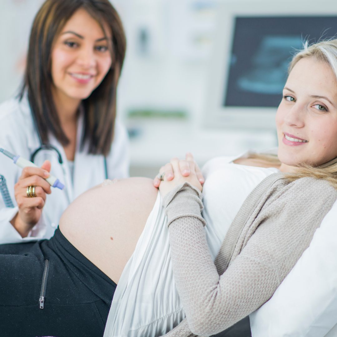 Woman and doctor smiling while getting an ultrasound