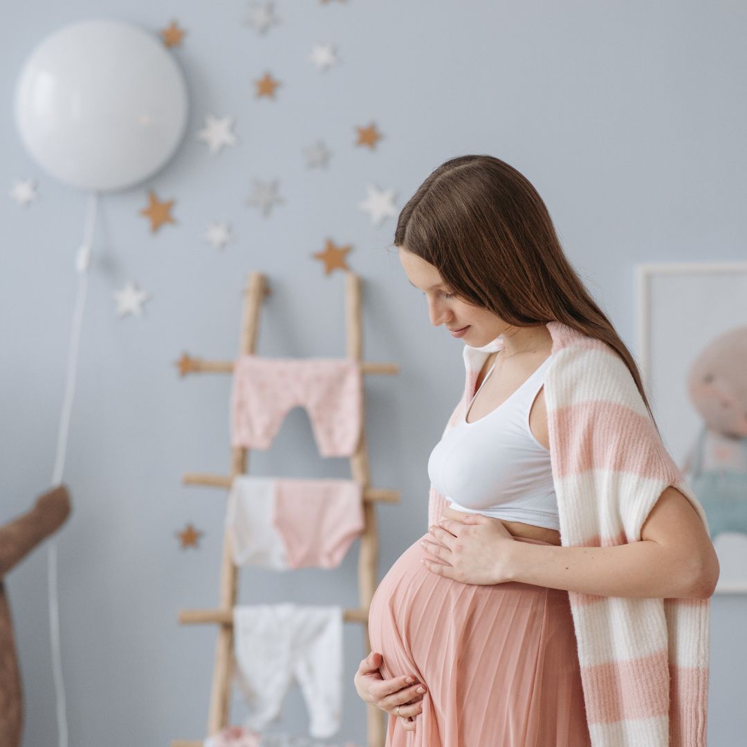 pregnant woman in comfy clothes holding her stomach